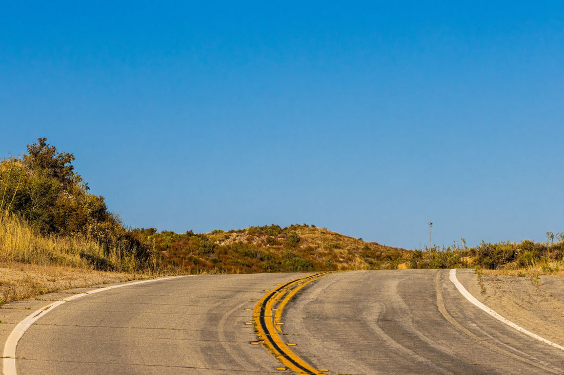 Empty desert highway running north through arid landscape on the drive from Saudi Arabia to Kuwait