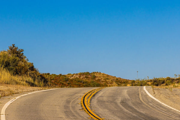 Empty desert highway running north through arid landscape on the drive from Saudi Arabia to Kuwait