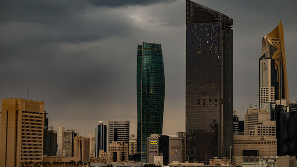 Office skyscrapers under cloudy skies in Kuwait City