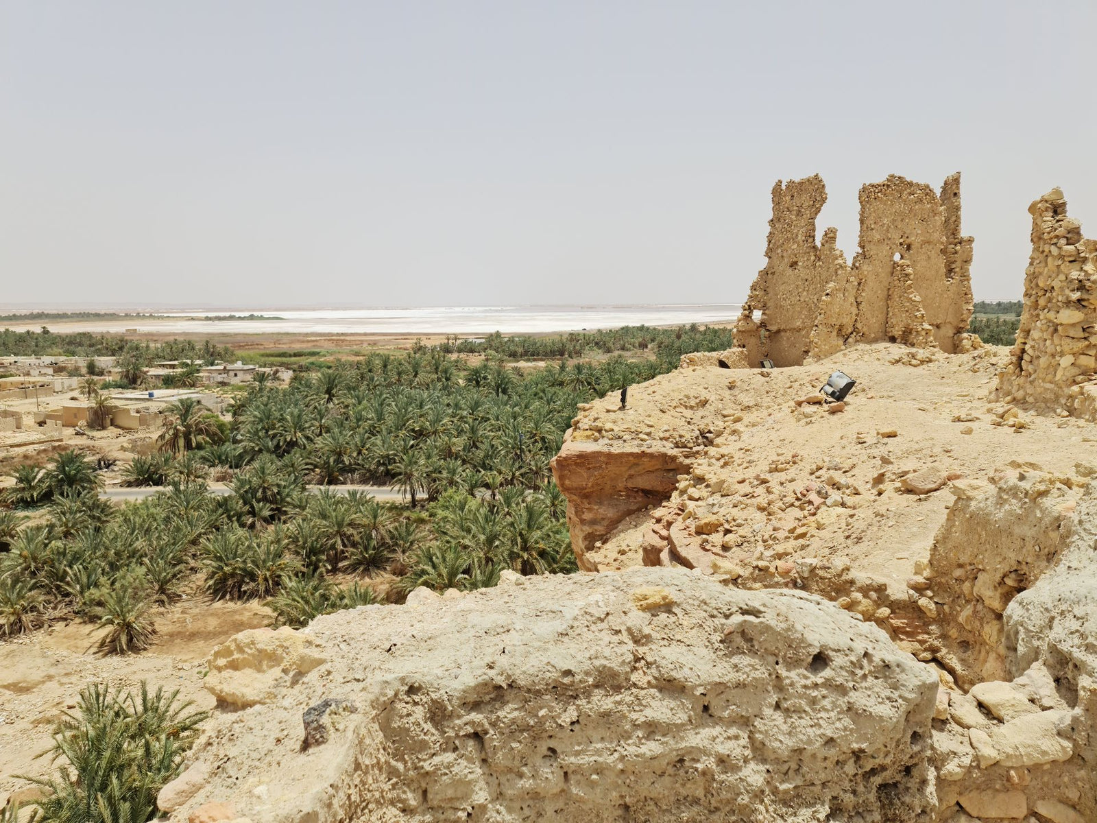 Old ruins in Matrouh, Egypt with a lush oasis landscape in the background.