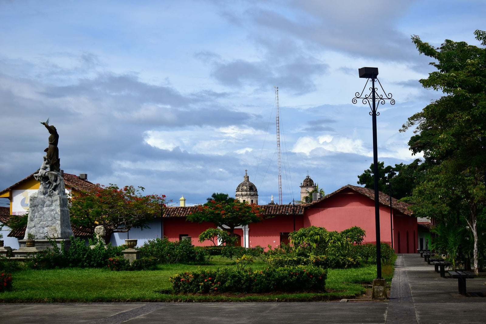 Colonial architecture and statue in a scenic town square on a cloudy day.