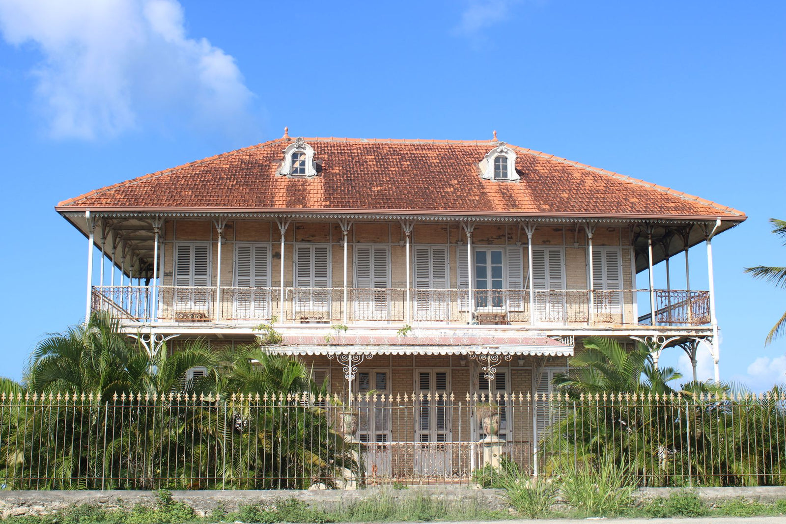 Historic French colonial house with brown roof in Guadeloupe captured on a sunny day.