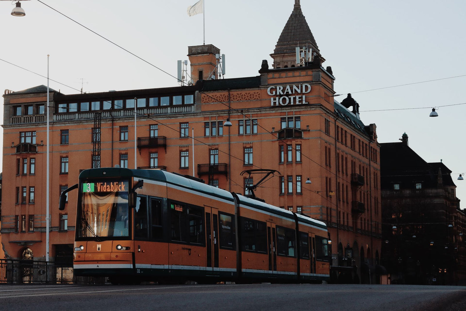 A city tram passing by the historic Grand Hotel in Norrköping, Sweden.