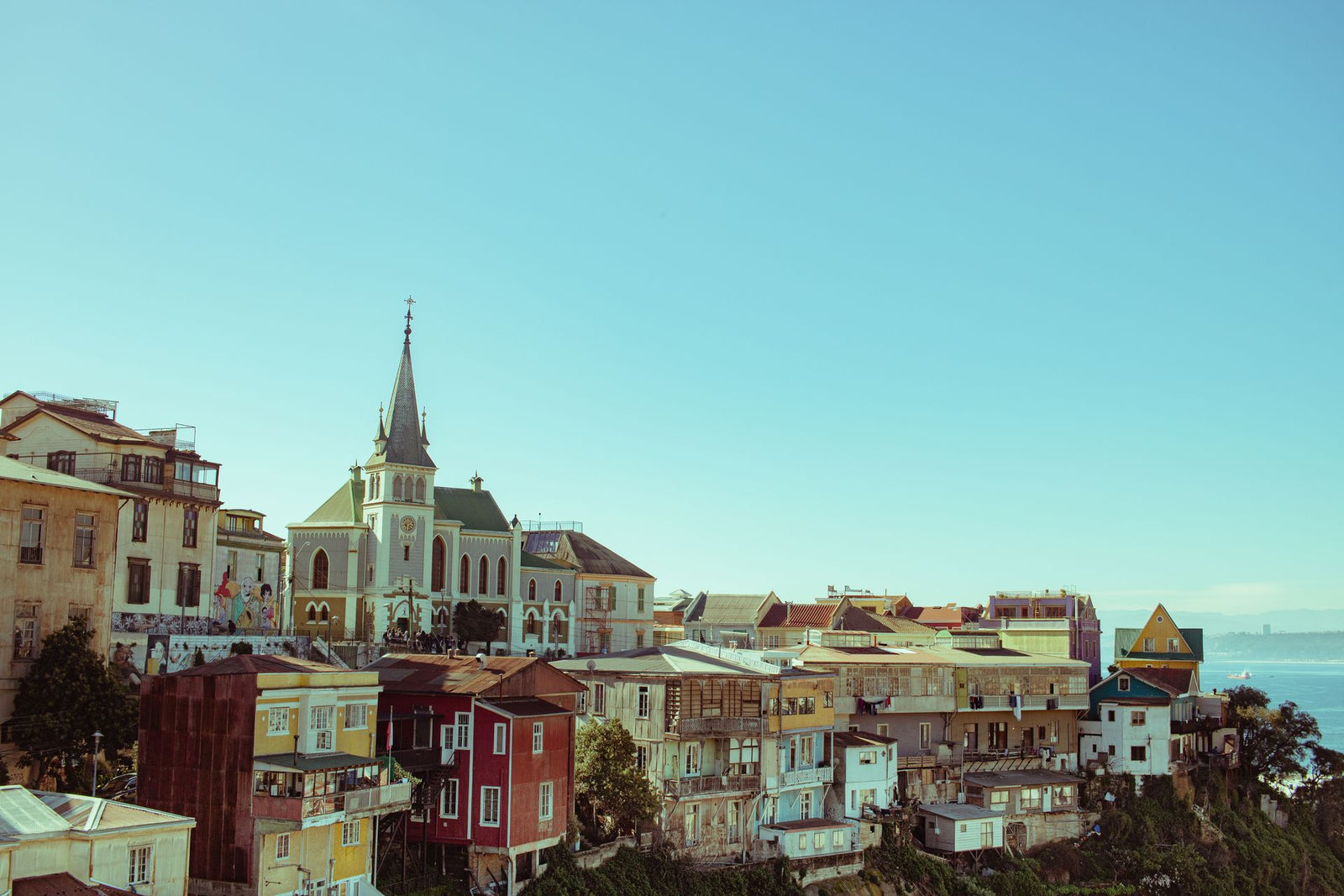 A beautiful view of Valparaíso's colorful houses and sea under a clear sky, capturing the city's charm.
