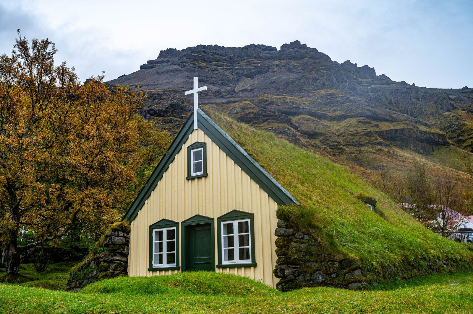 Beautiful Hofskirkja church with distinctive grass roof nestled in scenic Icelandic landscape.