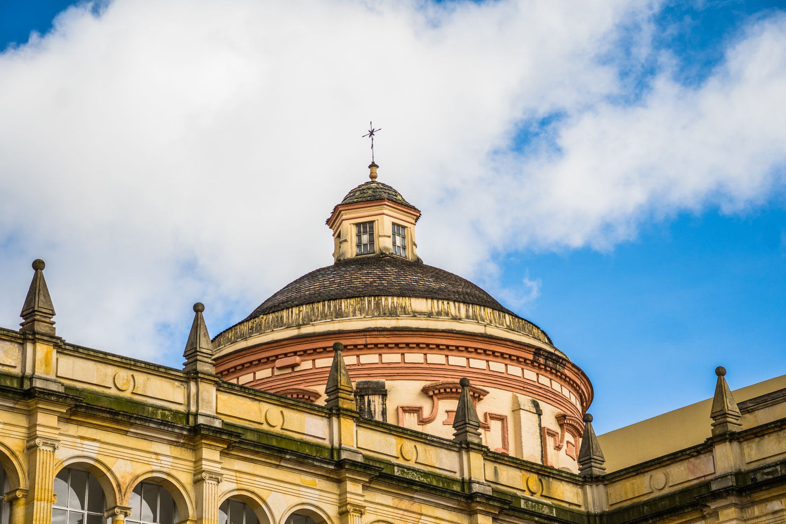 Capture of the classical dome against a vibrant blue sky in Bogotá, showcasing architecture.