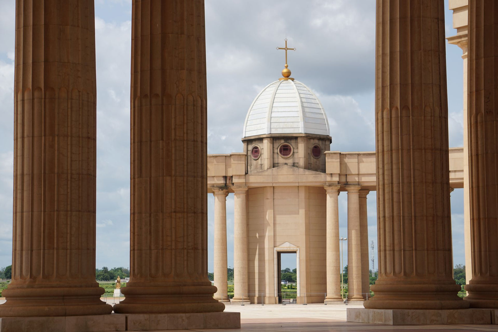 View of Basilica of Our Lady of Peace in Yamoussoukro, showcasing majestic columns and architecture.