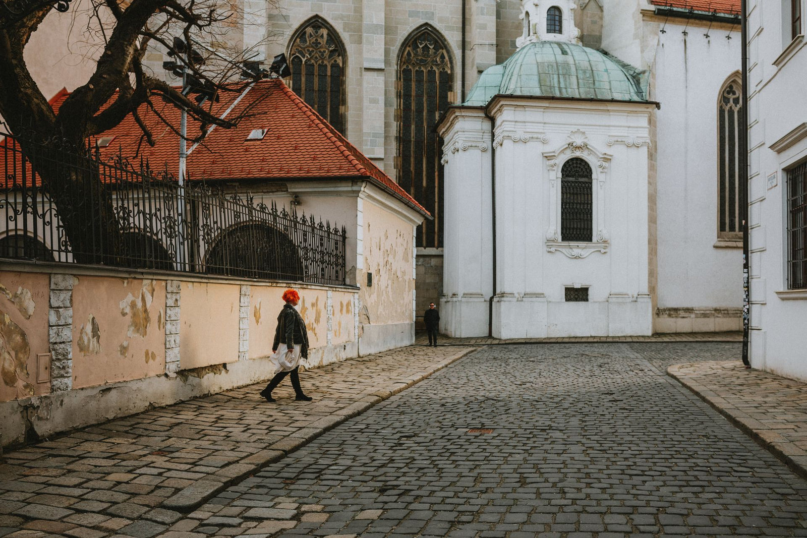 Street scene with St. Martin's Cathedral, showcasing cobblestone streets, gothic architecture, and a person walking.