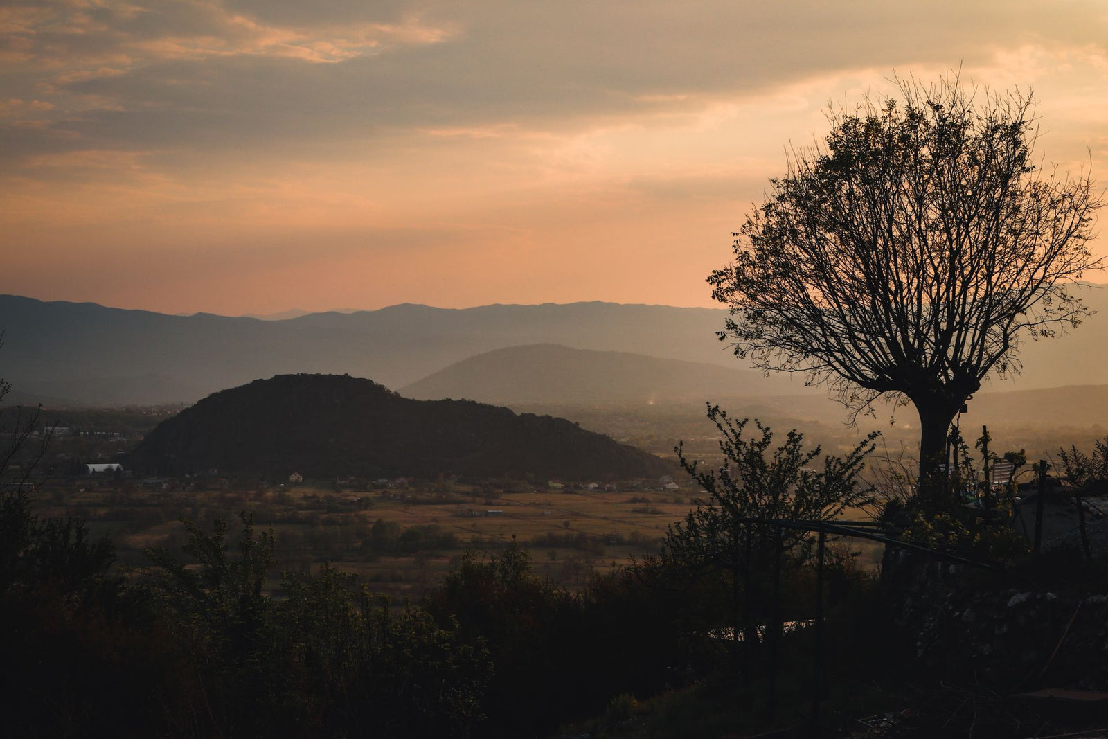 A peaceful view of Podgorica's rural hills and valleys at sunset, capturing nature's tranquil beauty.