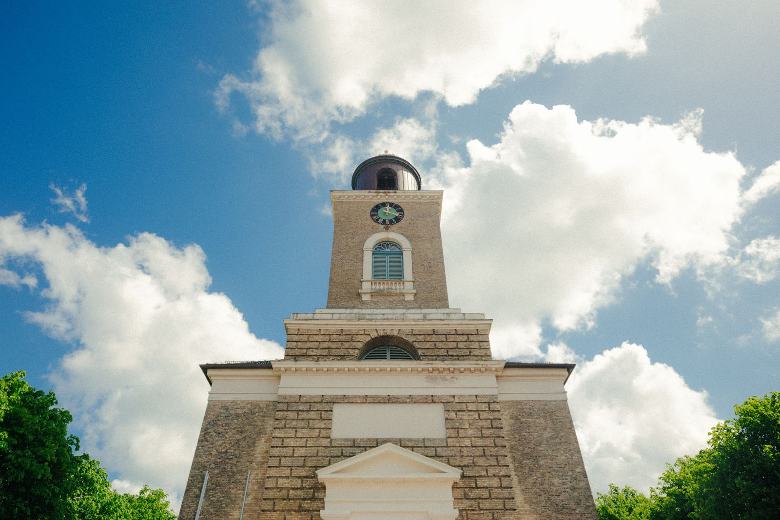 Low-angle view of St. Marienkirche tower in Husum, Germany with a cloudy sky backdrop.