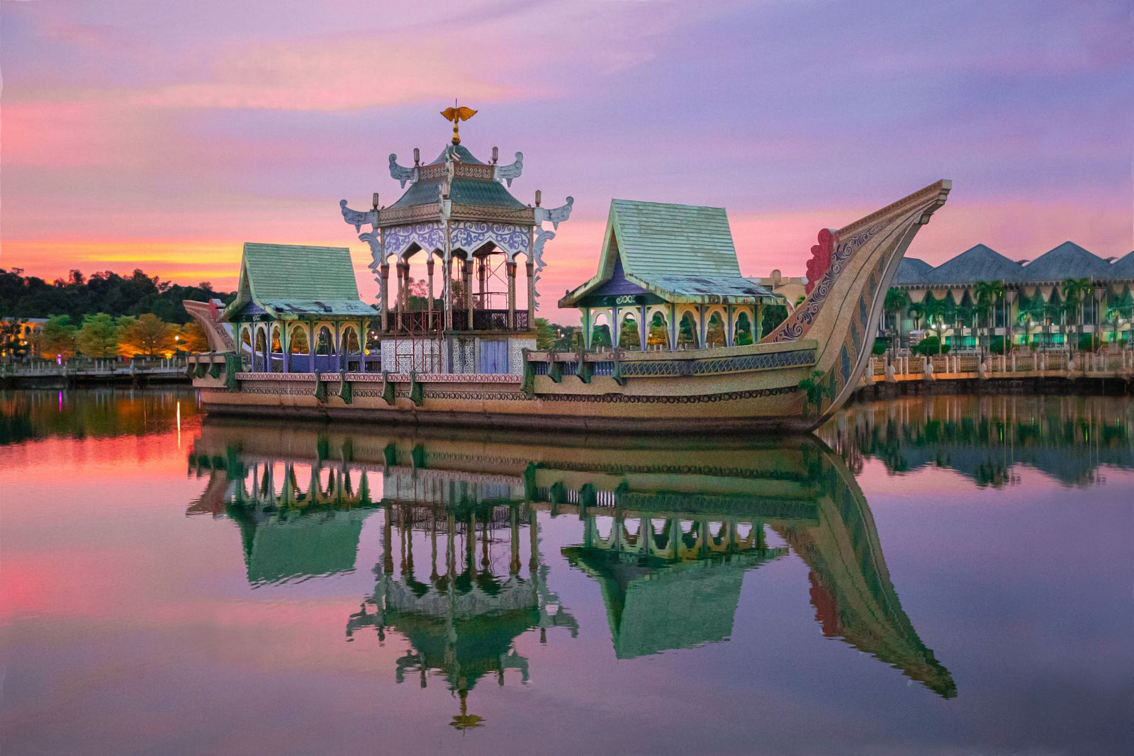 Stunning Brunei landmark reflecting in calm water during vibrant sunset.