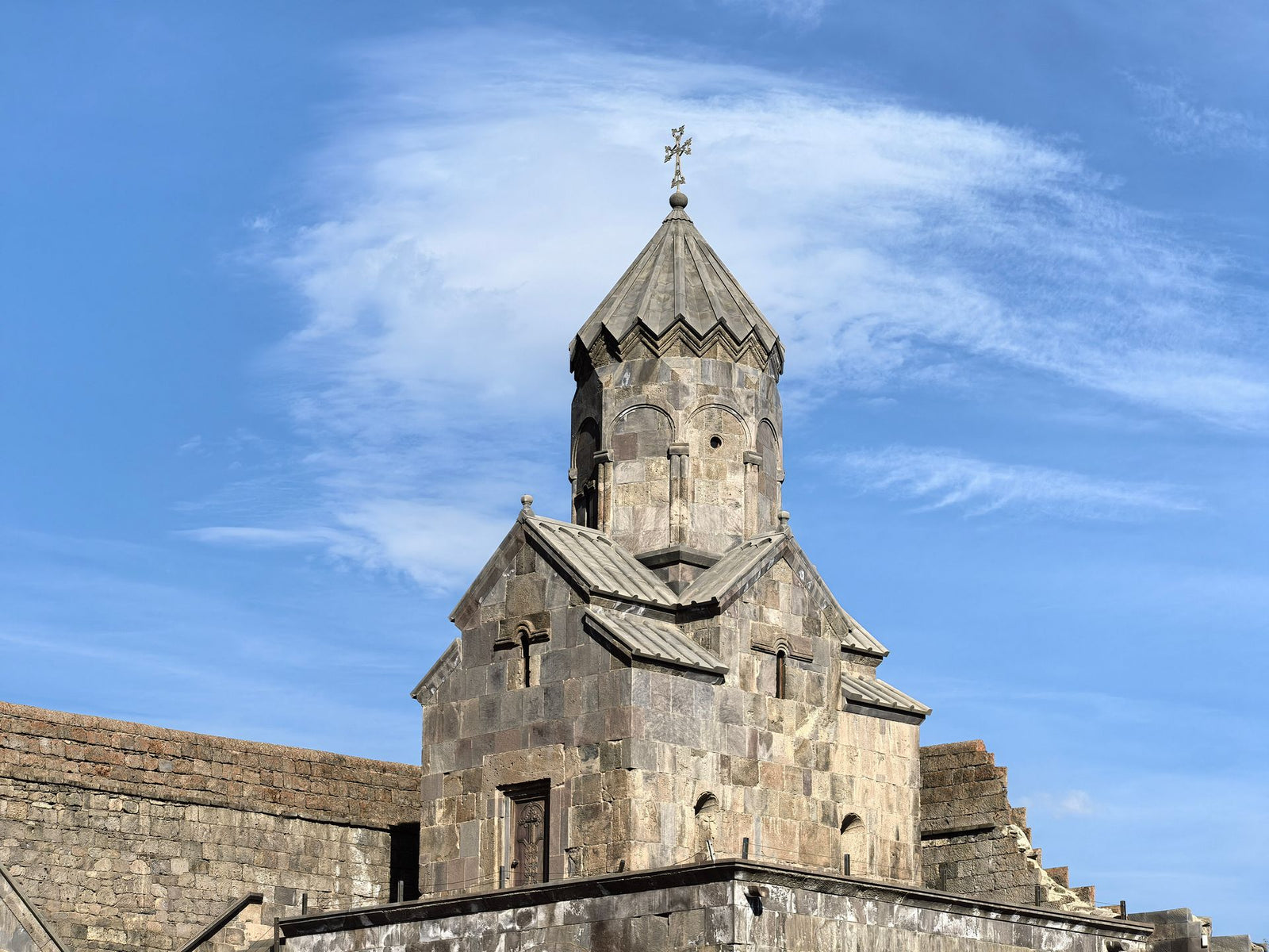Historic medieval church in Tatev, Armenia under clear blue skies.