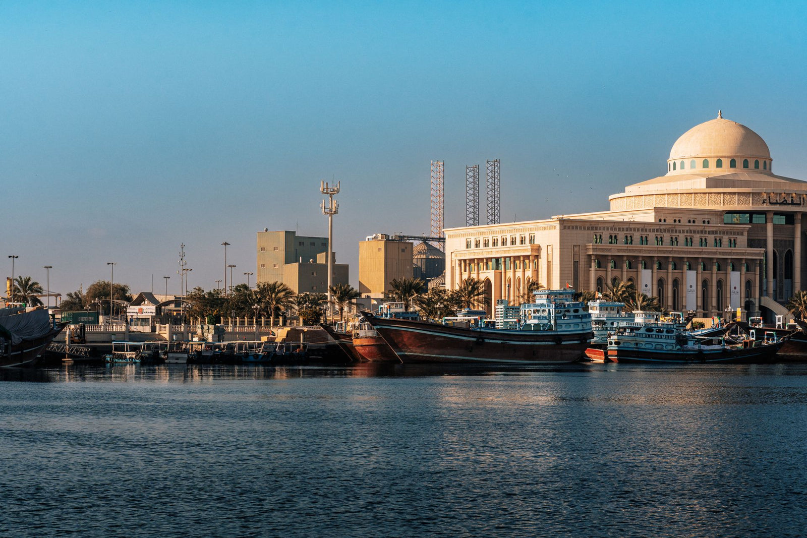 A scenic view of Sharjah's iconic waterfront with boats and traditional buildings.