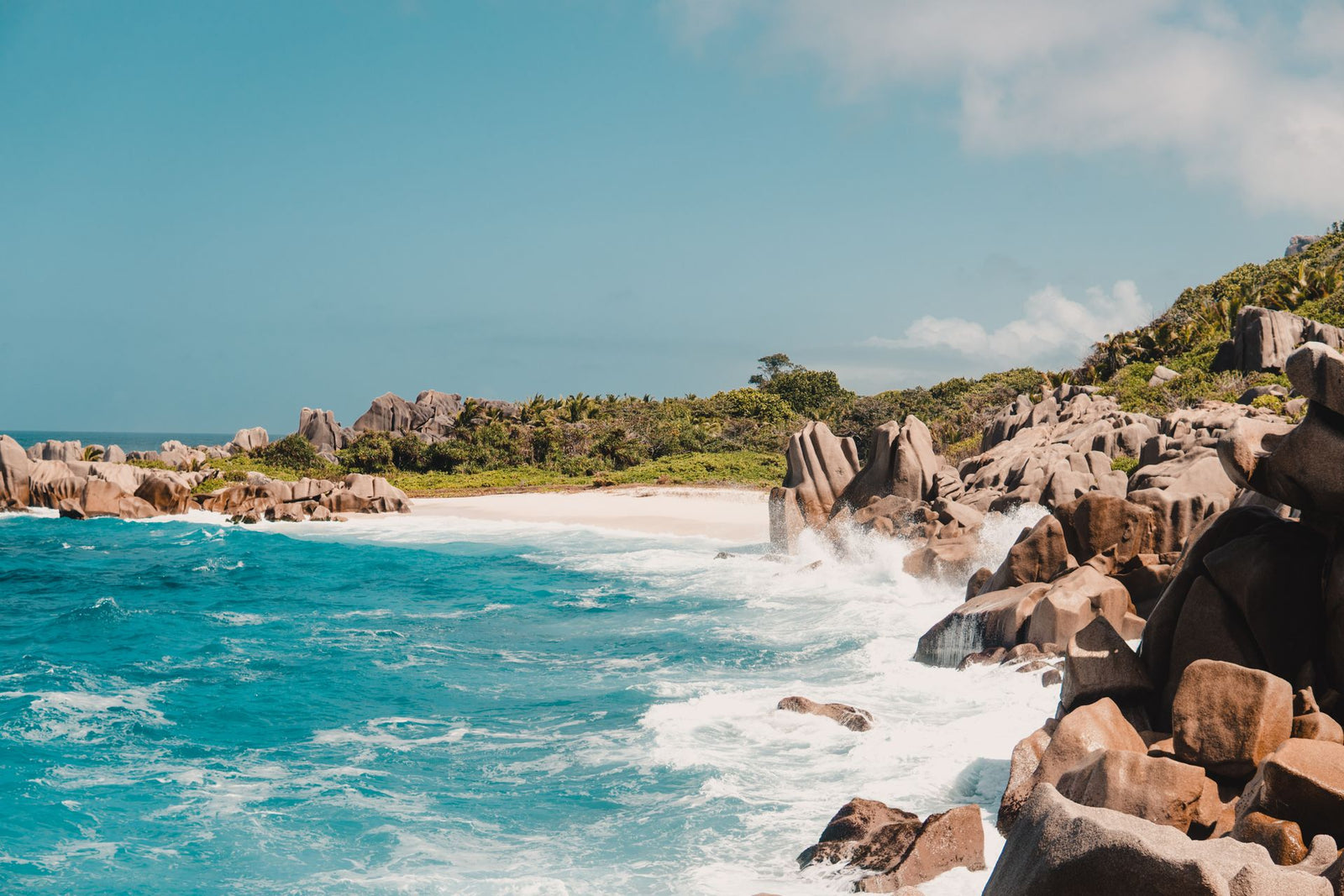 Explore the breathtaking seascape of Seychelles with crashing waves and distinct rock formations, perfect for nature lovers.